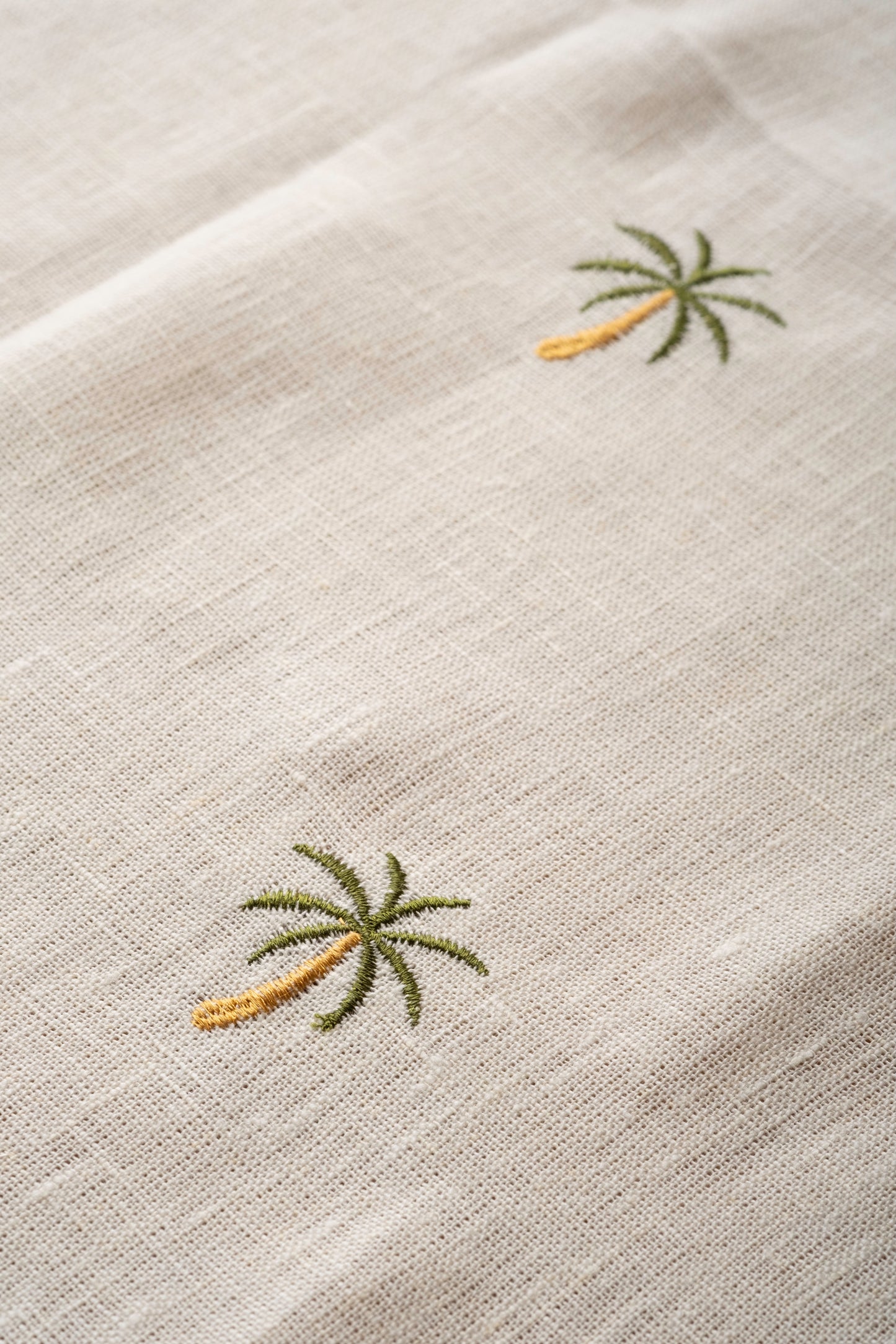 Close-up of Egyptian linen runner with embroidered palm trees.