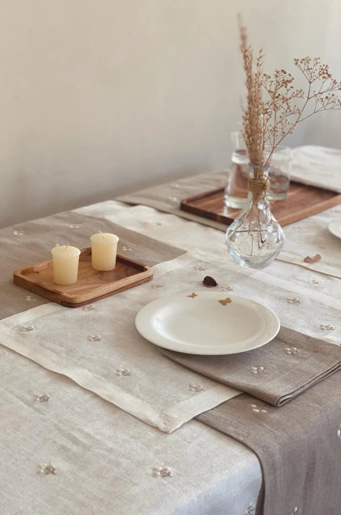 Table setting with a white Egyptian linen tablecloth, plates, candles, and decorative elements.